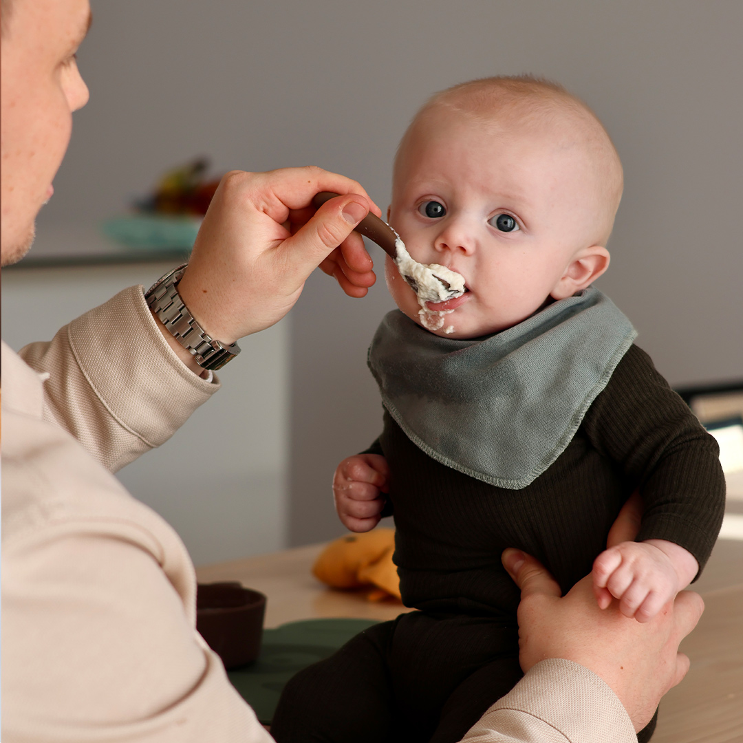 Baby being fed porridge