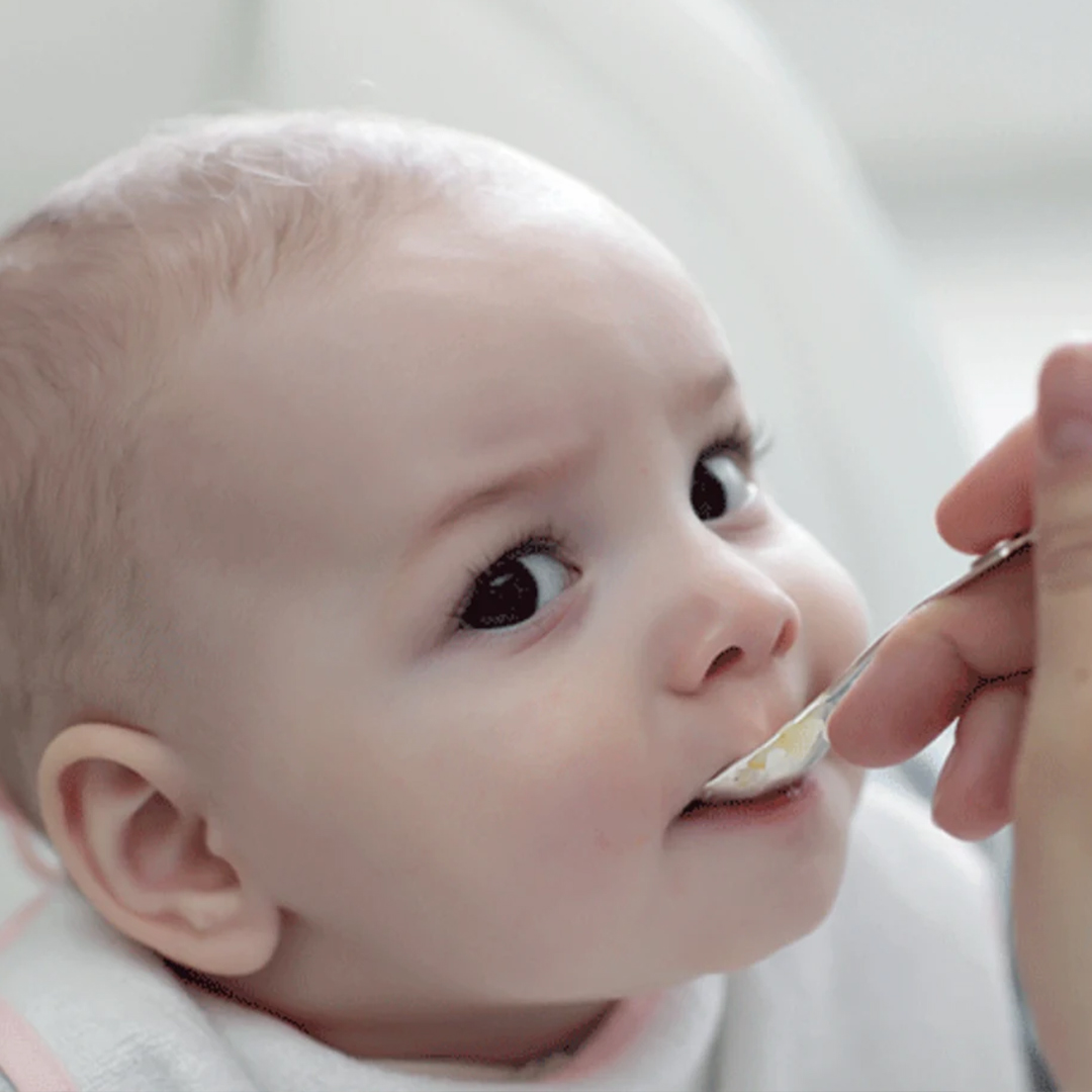 Baby eating apple and banana puree