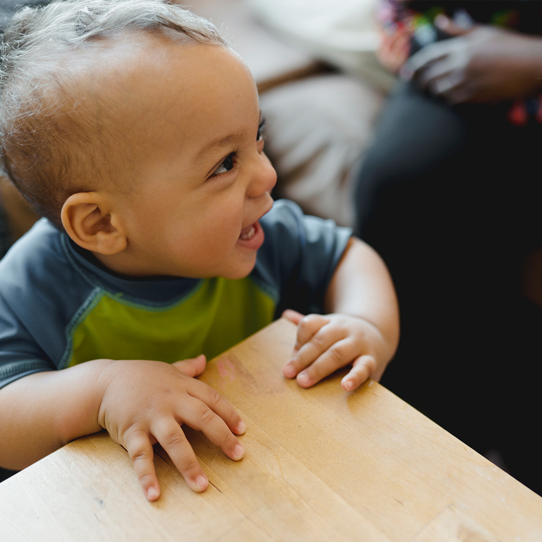 happy baby standing at table