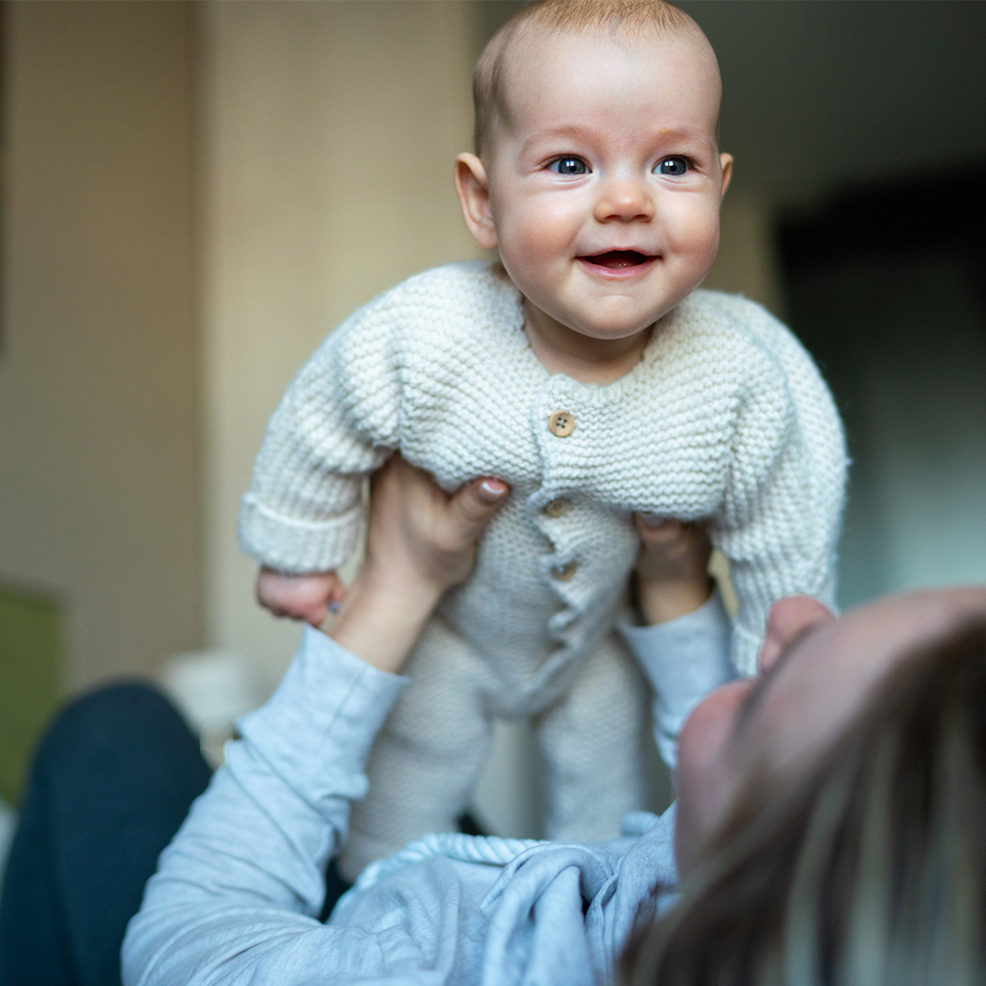 Baby held in air by parent